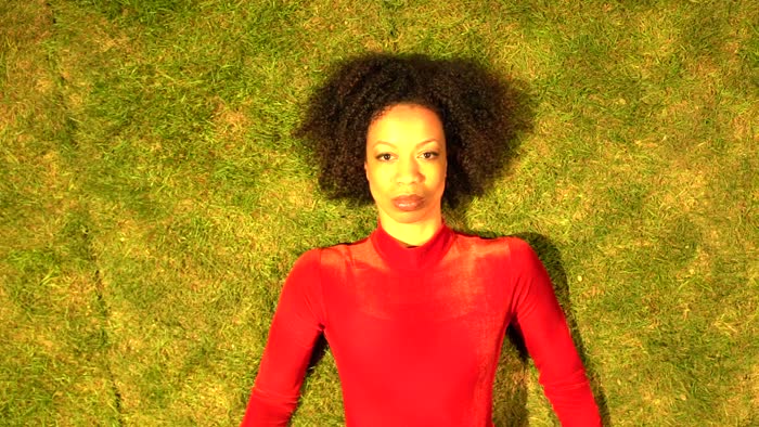 Close-up video of Gesel Mason lying on the grass for Rain